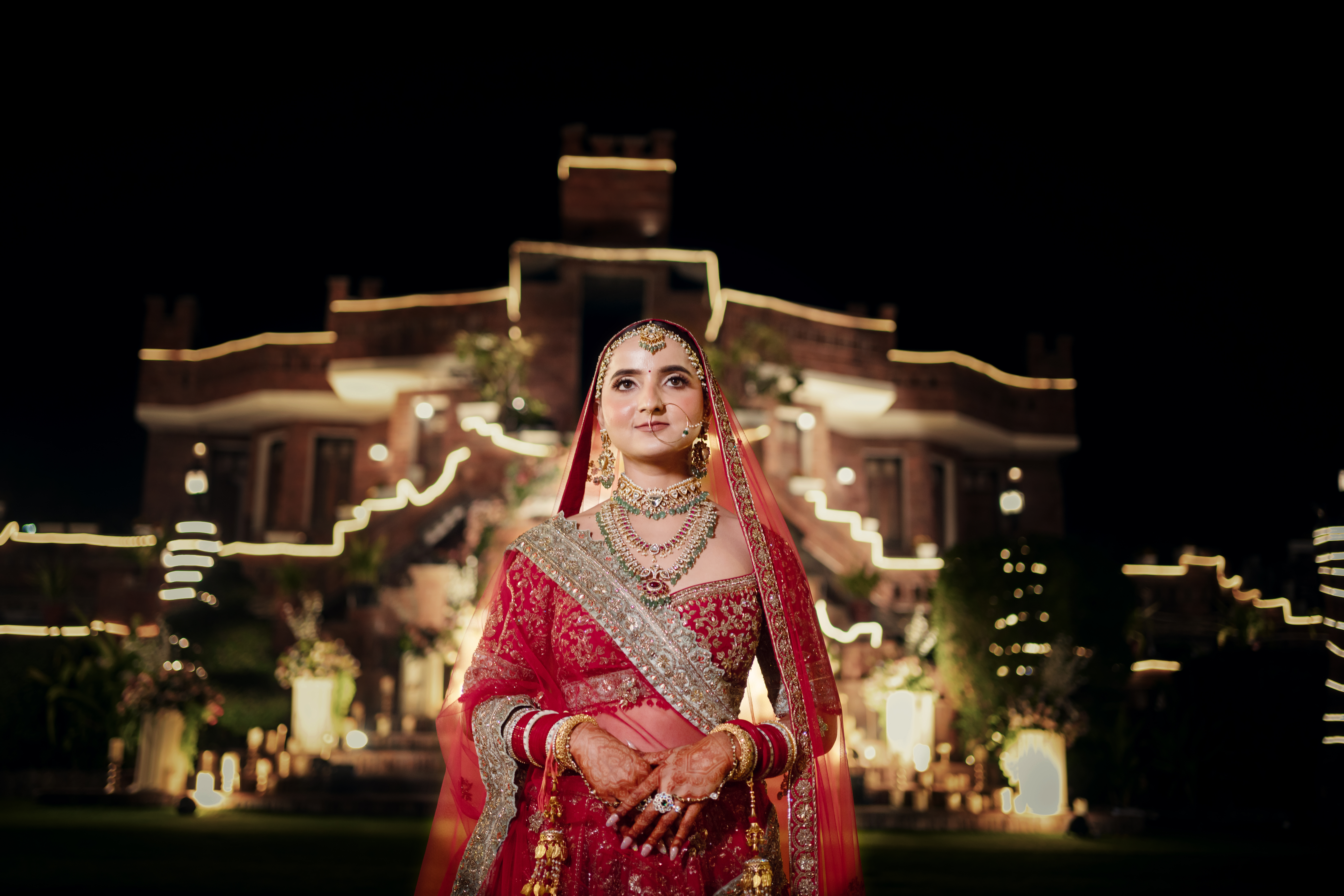 Bride at night in front of an illuminated palace, photographed by Mograa House